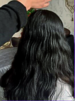 This photo shows a model with thick black, wavy hair. The therapist looks like she's ready to start the indian head massage.
